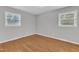 Bright bedroom with two windows, hardwood floors, and neutral walls at 704 Sunnybrook Rd, Raleigh, NC 27610