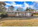 Brick ranch home with gray trim, covered porch, and well-maintained lawn at 704 Sunnybrook Rd, Raleigh, NC 27610