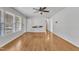 Bright living room featuring hardwood floors, a ceiling fan, and large windows at 704 Sunnybrook Rd, Raleigh, NC 27610