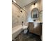 Updated bathroom with marble shower surround, wood vanity and herringbone floors at 72 Beverly Dr, Durham, NC 27707