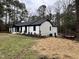 White ranch house with black trim, landscaping, and deck at 72 Beverly Dr, Durham, NC 27707