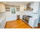 Modern kitchen with stainless steel appliances, white cabinets, quartz countertops, and hardwood floors at 72 Beverly Dr, Durham, NC 27707