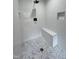 Large walk-in shower with a built-in bench and pebble floor at 72 Beverly Dr, Durham, NC 27707