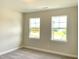 Neutral bedroom showcasing natural light through two windows, plush carpeting, and fresh paint at 82 N Stagecoach Dr, Wendell, NC 27591