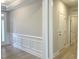 Dining room with classic wainscoting, wood flooring, neutral paint, and glass door entrance at 82 N Stagecoach Dr, Wendell, NC 27591