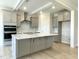 Modern kitchen with gray cabinetry, stainless steel appliances, and an island with quartz countertop at 82 N Stagecoach Dr, Wendell, NC 27591