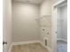 Functional laundry room with shelving, light wood flooring, and hookups for washer and dryer at 82 N Stagecoach Dr, Wendell, NC 27591