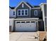 Two-story home with gray siding, white garage doors, and a landscaped yard at 8947 Kennebec Crossing Dr # 53, Angier, NC 27501