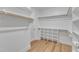 Walk-in closet with built-in shelving units and wooden rods for organized storage at 9342 Turkey Way, Middlesex, NC 27557