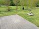 Backyard with brick patio, fire pit, and wooded backdrop, perfect for outdoor enjoyment at 100 Churchill Rd, Louisburg, NC 27549
