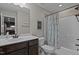 Bathroom vanity with single sink, framed mirror, and tub/shower combination with patterned curtain at 100 Churchill Rd, Louisburg, NC 27549