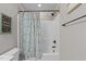 A tub/shower with a patterned curtain and a vintage-style picture hanging in the bathroom at 100 Churchill Rd, Louisburg, NC 27549