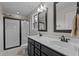Bathroom featuring a double vanity sink, framed mirror, and walk-in shower with a glass enclosure at 100 Churchill Rd, Louisburg, NC 27549