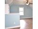 A bright empty room with sky blue walls, one double window, and stylish vinyl flooring at 100 Churchill Rd, Louisburg, NC 27549