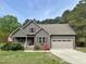 Charming home with a two-car garage, landscaped front yard, and inviting front porch at 100 Churchill Rd, Louisburg, NC 27549