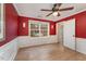 Red-walled bedroom with hardwood floors and ample natural light at 103 Burham Ct, Apex, NC 27502