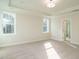 Bright bedroom with light carpet and natural light from two windows, open bathroom door at 116 Bearwallow Forest Way, Wendell, NC 27591