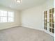 A bright room with carpet and a window and glass paneled double doors at 116 Bearwallow Forest Way, Wendell, NC 27591