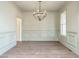 Elegant dining room with decorative trim, modern chandelier, and light hardwood floors at 116 Bearwallow Forest Way, Wendell, NC 27591