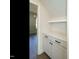 Hallway with storage area, white cabinets, black hardware, and wood flooring at 116 Bearwallow Forest Way, Wendell, NC 27591