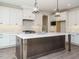 Bright kitchen with white cabinets, a dark island, pendant lighting, and stainless steel appliances at 116 Bearwallow Forest Way, Wendell, NC 27591