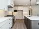 Modern kitchen featuring white cabinets, stainless steel appliances, and a large island with quartz countertops at 116 Bearwallow Forest Way, Wendell, NC 27591