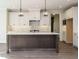 Spacious kitchen with white cabinets, a dark island with pendant lights, and modern appliances at 116 Bearwallow Forest Way, Wendell, NC 27591