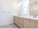 Bright bathroom featuring double vanity with wood cabinets, large mirrors, quartz countertops, and tile floors at 121 Big Bradley Way, Wendell, NC 27591