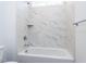 A tiled shower-bath combo features a built-in shelf and stainless steel hardware at 121 Big Bradley Way, Wendell, NC 27591