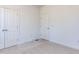 A bedroom with neutral carpet, trim, and white walls features two closets and multiple doors at 121 Big Bradley Way, Wendell, NC 27591