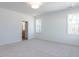 Spacious bedroom featuring neutral carpeting, large windows, recessed lighting, and doorway to ensuite bath at 121 Big Bradley Way, Wendell, NC 27591