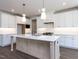 A bright kitchen features white cabinets, stainless appliances, and a large island with a white countertop at 121 Big Bradley Way, Wendell, NC 27591