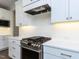 A gourmet kitchen features stainless steel oven, white countertops and cabinets, with a stainless steel vent hood at 121 Big Bradley Way, Wendell, NC 27591