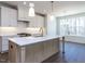 Bright kitchen with a large island, white cabinets, stainless appliances, and pendant lighting at 121 Big Bradley Way, Wendell, NC 27591