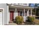 A closer look at the home's front porch, featuring brick detailing, white columns, and shrubbery at 1305 Turks Head Ct, Zebulon, NC 27597