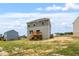 Two-story home featuring a back deck and grassy backyard with trees and adjacent homes in the distance at 139 Grove Township Way, Angier, NC 27501