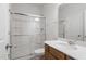 Bright bathroom with a glass shower door and a wooden vanity with a white countertop at 139 Grove Township Way, Angier, NC 27501