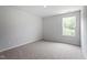 Bright, carpeted bedroom features a neutral color scheme and a large window with treed outdoors view at 139 Grove Township Way, Angier, NC 27501