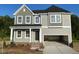 Two-story home featuring a modern elevation, inviting front porch, and attached two-car garage at 139 Grove Township Way, Angier, NC 27501