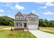 Inviting two-story home with gray siding, a two-car garage, and a well-manicured front yard at 139 Grove Township Way, Angier, NC 27501