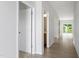 Bright hallway with wood-look flooring and multiple doorways, offering a glimpse into other rooms at 139 Grove Township Way, Angier, NC 27501