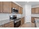 This kitchen is equipped with stainless steel appliances, granite counters, and wooden cabinetry at 139 Grove Township Way, Angier, NC 27501