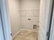 Tiled laundry room with shelving and white trim at 139 Grove Township Way, Angier, NC 27501