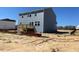 This home features a small wooden deck, a light blue siding, and a large backyard at 157 Grove Township Way, Angier, NC 27501