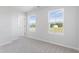 Bright bedroom with two windows, neutral carpet, and fresh, light gray paint at 157 Grove Township Way, Angier, NC 27501