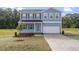 Charming two-story home with blue siding, black shutters, and a well-maintained front yard at 157 Grove Township Way, Angier, NC 27501