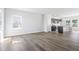 Bright and airy living area with wood-look floors, connecting to the kitchen, and windows offering ample light at 157 Grove Township Way, Angier, NC 27501