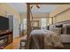 Comfortable bedroom with a four-poster bed, ceiling fan, and wood floors at 1703 Happiness Hill Ln, Raleigh, NC 27614