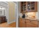 Convenient butler's pantry with granite countertop, wooden cabinets, and easy access to the dining area at 1703 Happiness Hill Ln, Raleigh, NC 27614