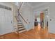 Inviting foyer with hardwood floors, staircase, and doorway leading to the kitchen at 1703 Happiness Hill Ln, Raleigh, NC 27614